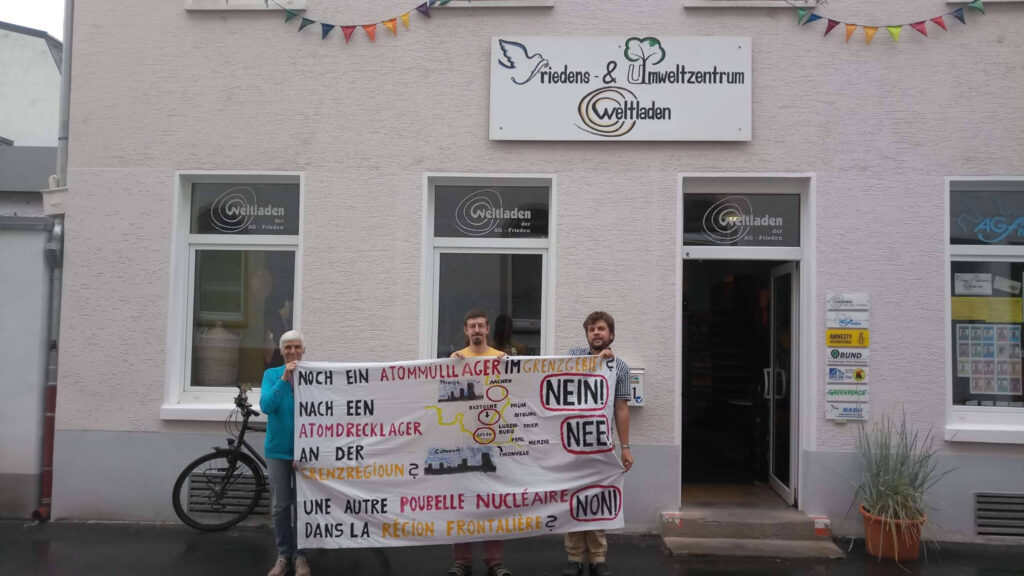 Mitglieder des Anti-Atom-Netz Trier halten vor dem Trierer Friedens- und Umweltzentrum das selbst erstellte Transparent gegen das geplante belgische Atommüllendlager hoch.